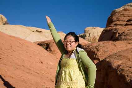 Asian Girl with Arm Raised on Red Rocks