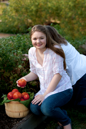 Teen Girl in Garden with Tomato